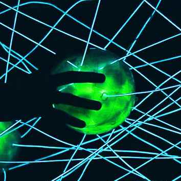 A hand touching a green-lit ball